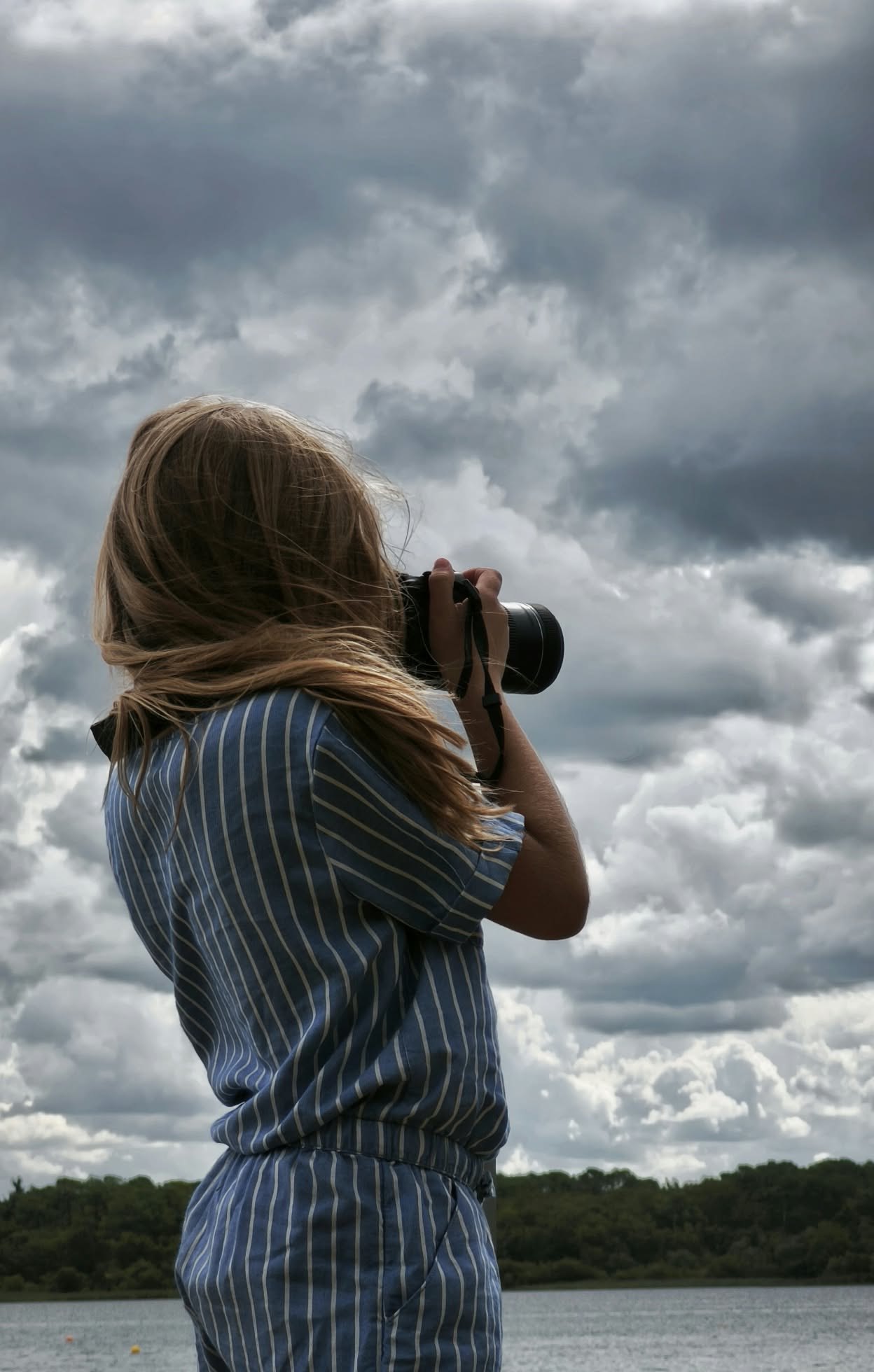 Photographe face à un ciel nuageux