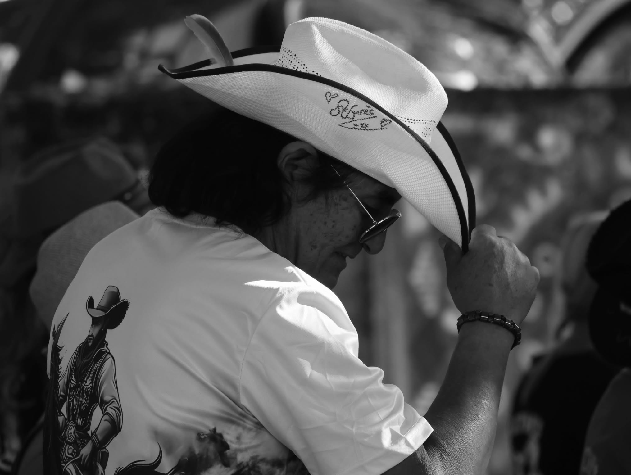 Portrait noir et blanc d’une personne ajustant son chapeau
